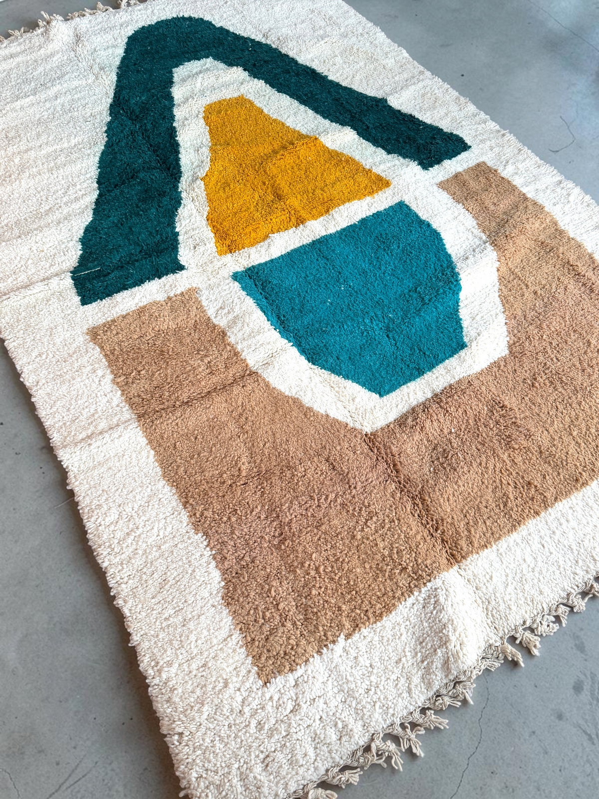 Tapis Beni Ouarain YAAS en laine artisanale avec motifs géométriques colorés terracotta, jaune et bleu sur fond crème