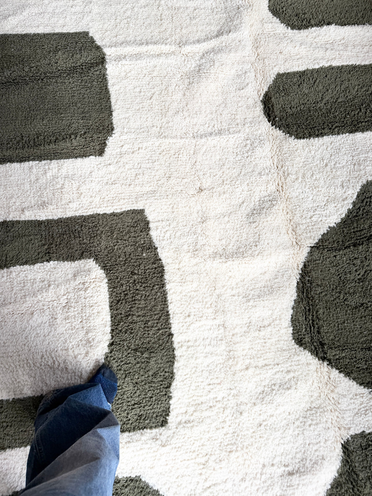 Tapis berbère YAAS en laine de mouton blanc et gris avec motifs géométriques abstraits, vue en plongée.
